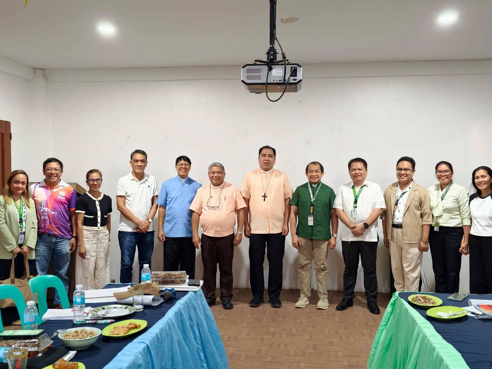 Members of the Board of Trustees standing together for a group photograph in the school's Audio-Visual Room