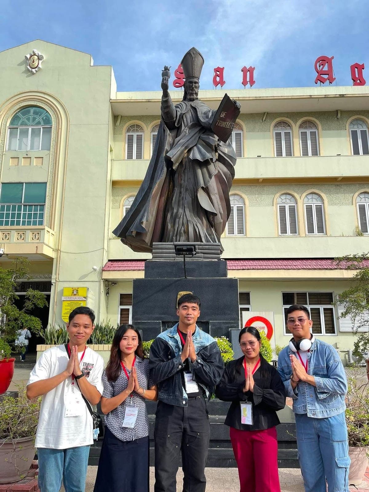 The five St. Joseph's Academy teachers standing before the statue of St. Augustine outside the University of San Agustin