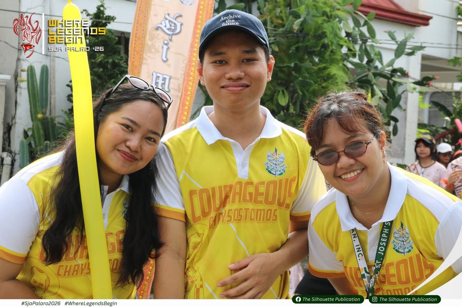 Three Guardians in the yellow jerseys of the Chrysostomos, the Courageous, smiling beside their house banner