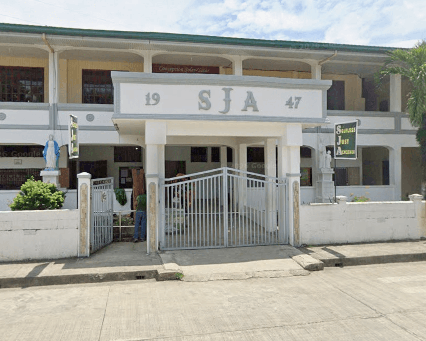 The facade of St. Joseph's Academy of Malinao, showing its 1947 founding year and Selfless, Just, Achiever banner